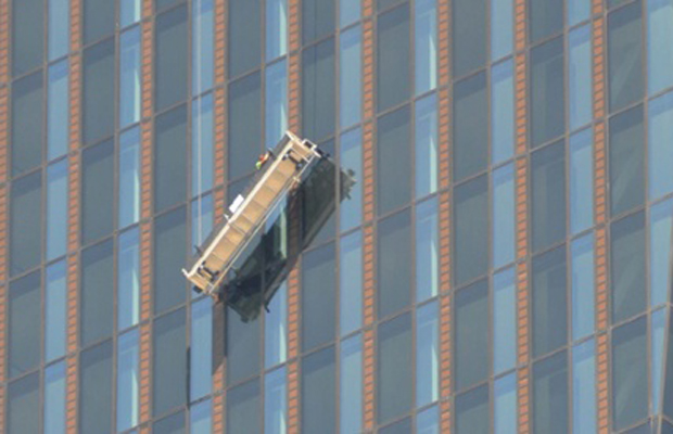 The gantry tips precariously on the DC Tower as the men hang on for life